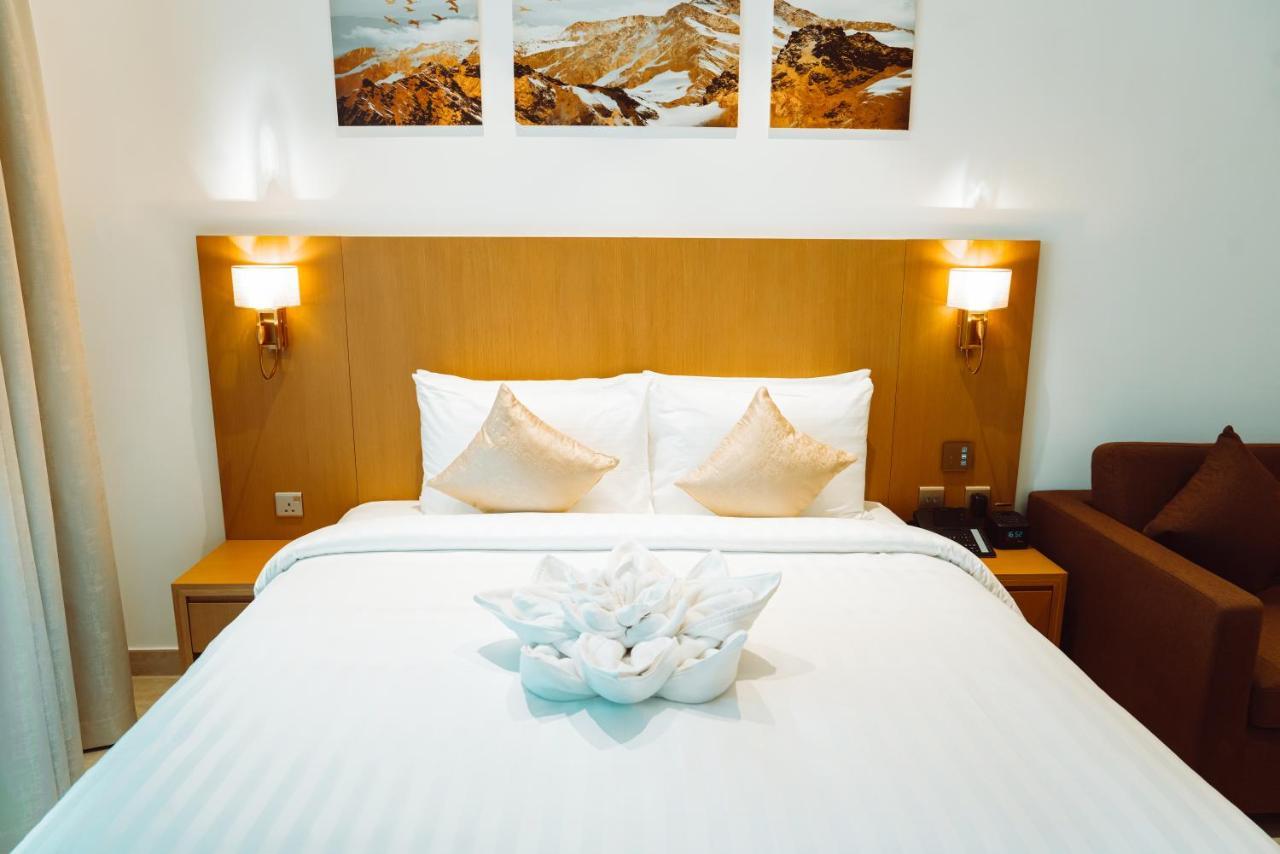 He Hotel Apartments Dubai Quarto foto A bed with a bedsheet